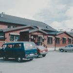 A bus parked in front of a red building