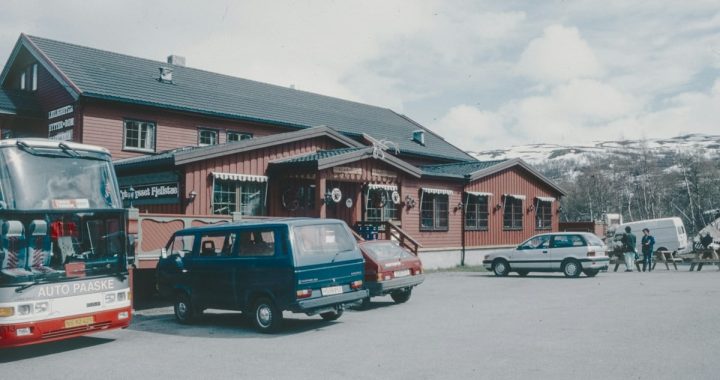 A bus parked in front of a red building